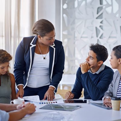 seated young adult students being mentored by a professional advisor