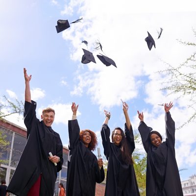 commencement students throwing up in the air their caps outside